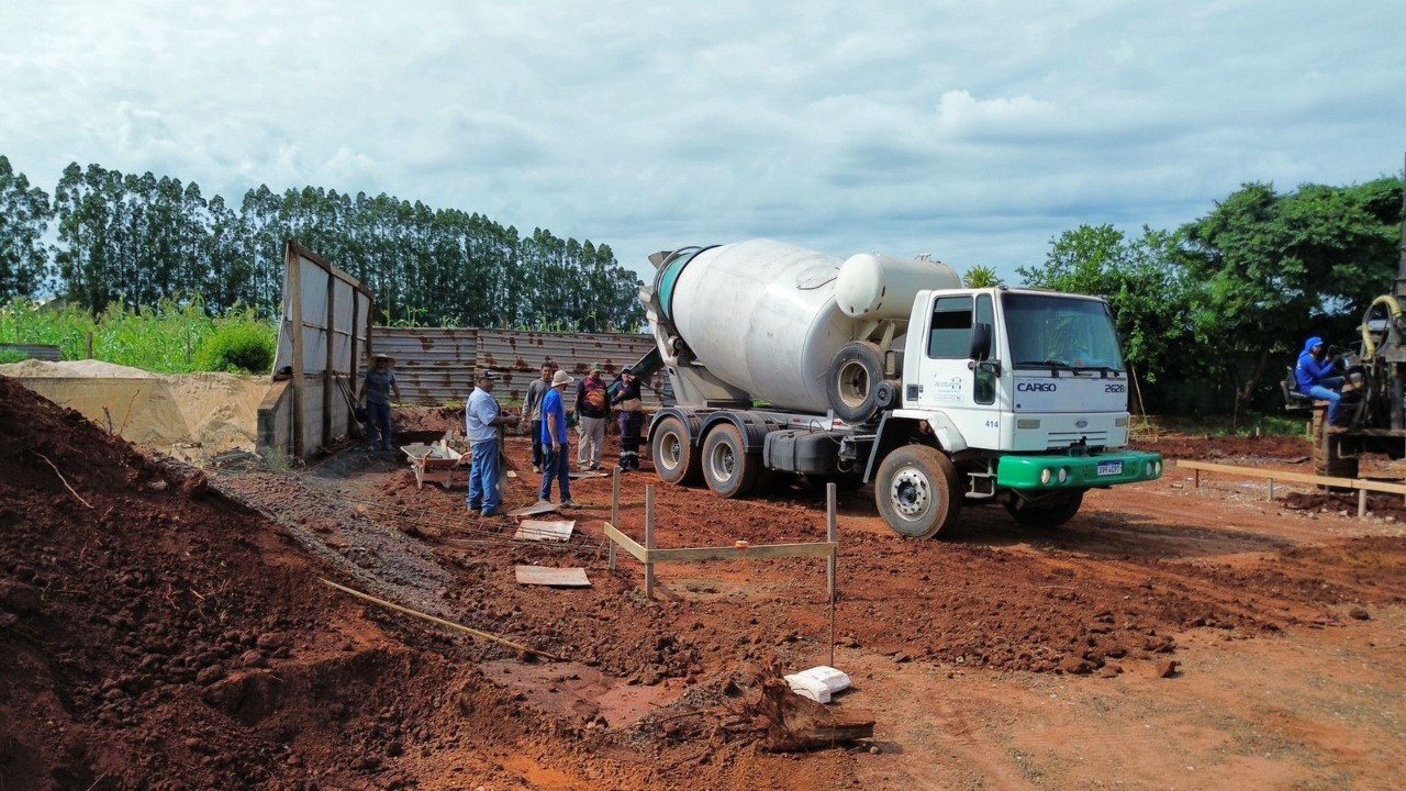 Equipe e caminhão betoneira durante a execução de uma obra